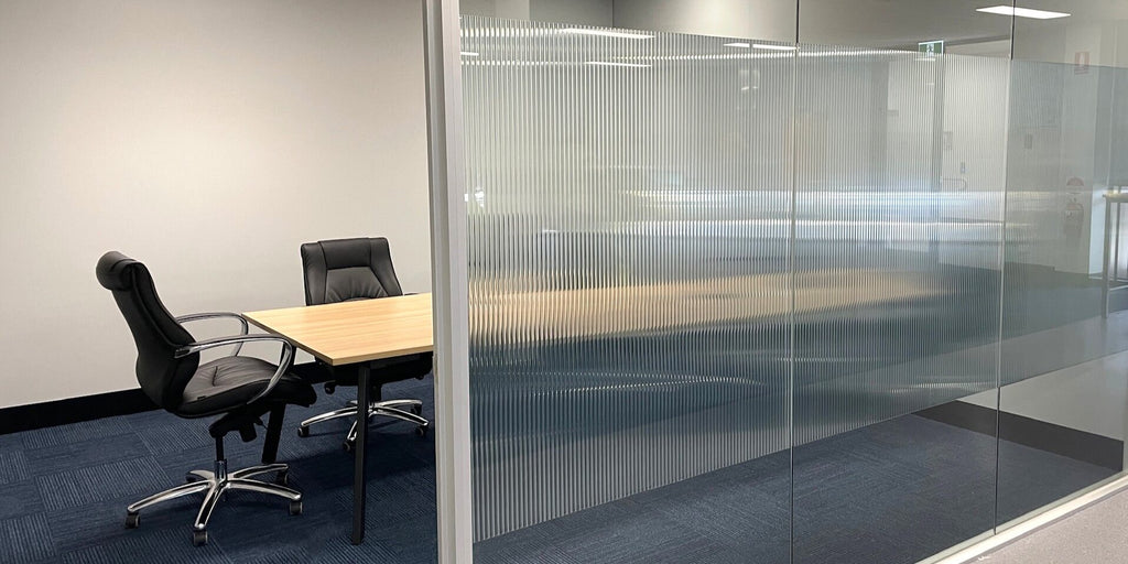 Glass office partition with reeded glass film for privacy band