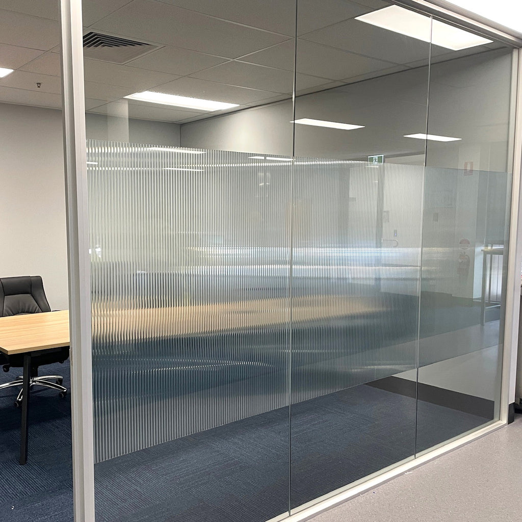 Glass office partition with reeded glass film for privacy band