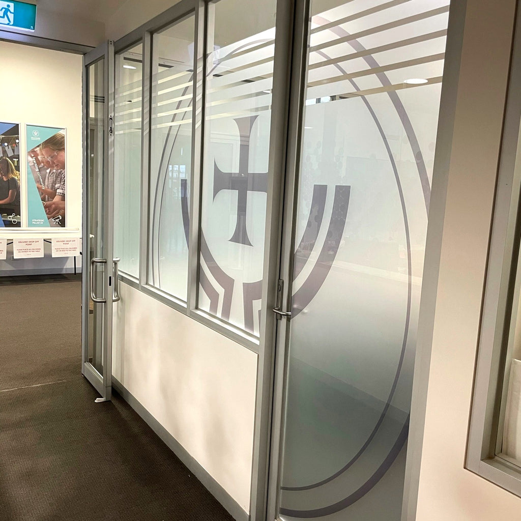 Glass partition with a logo on a wall inside a building
