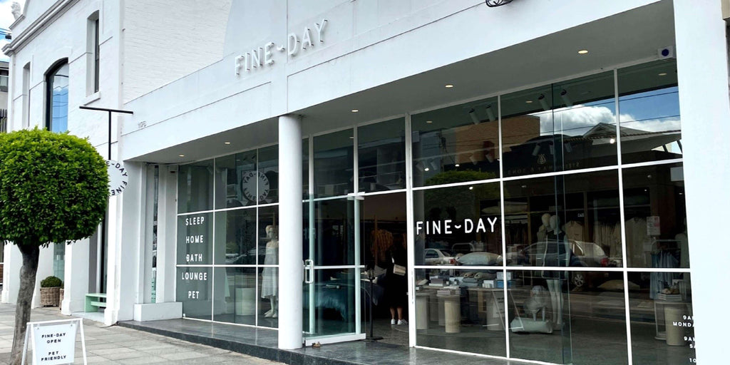 Storefront of 'FINE-DAY' with large glass windows and visible interior.