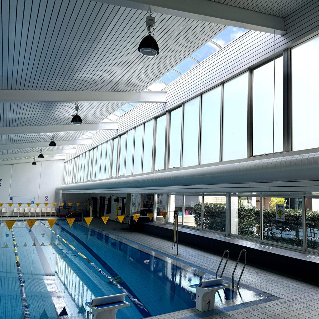 Indoor school swimming pool with large windows and a frosted film applied